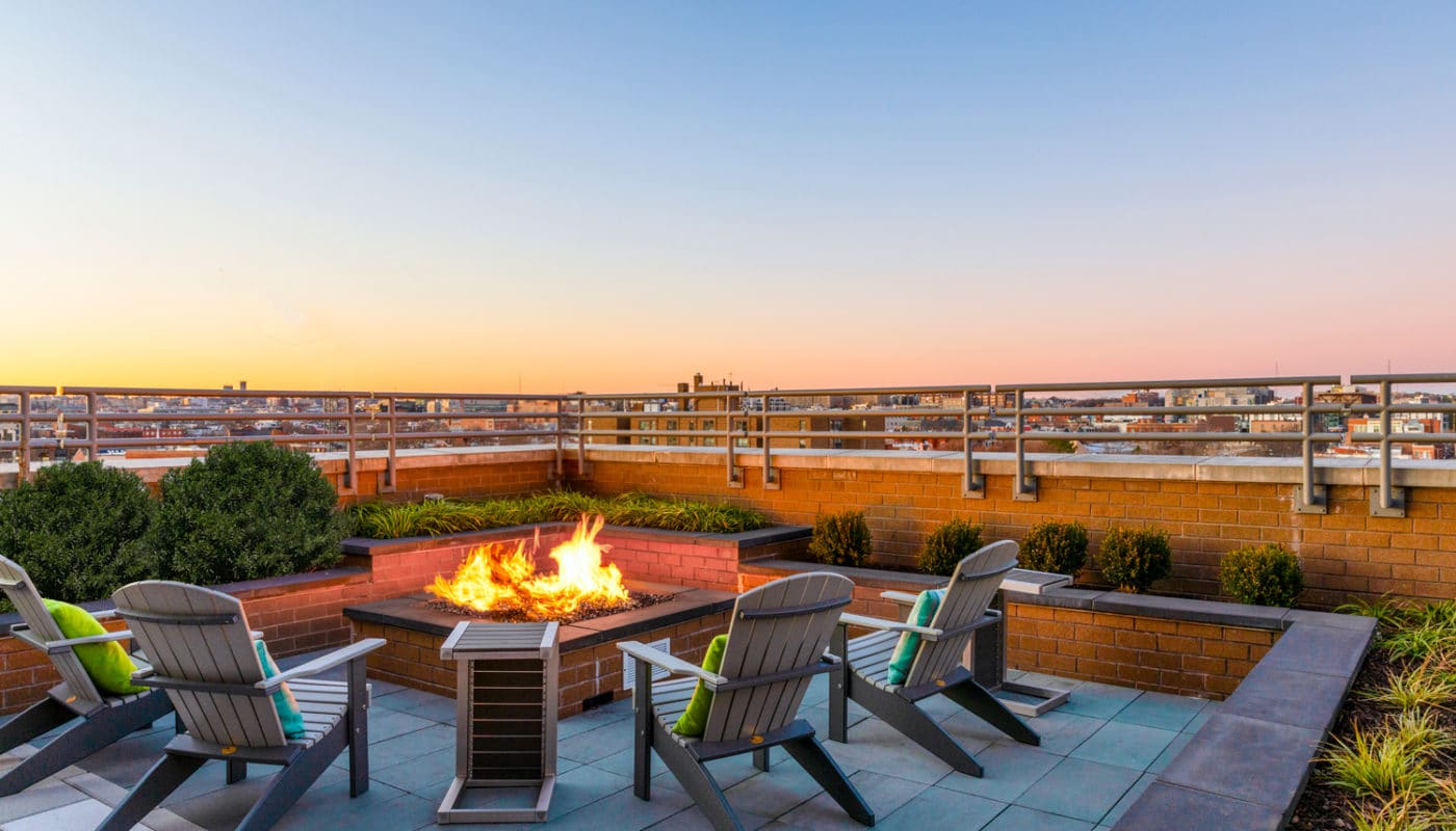 rooftop lounge with social seating, fire pit and view of the city - jefferson marketplace luxury apartments in washington dc