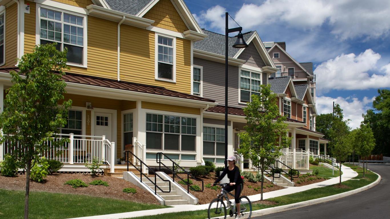 arlington 360 exterior view of town homes, with sidewalks, a person riding their bicycle and green landscaping - jefferson apartment group