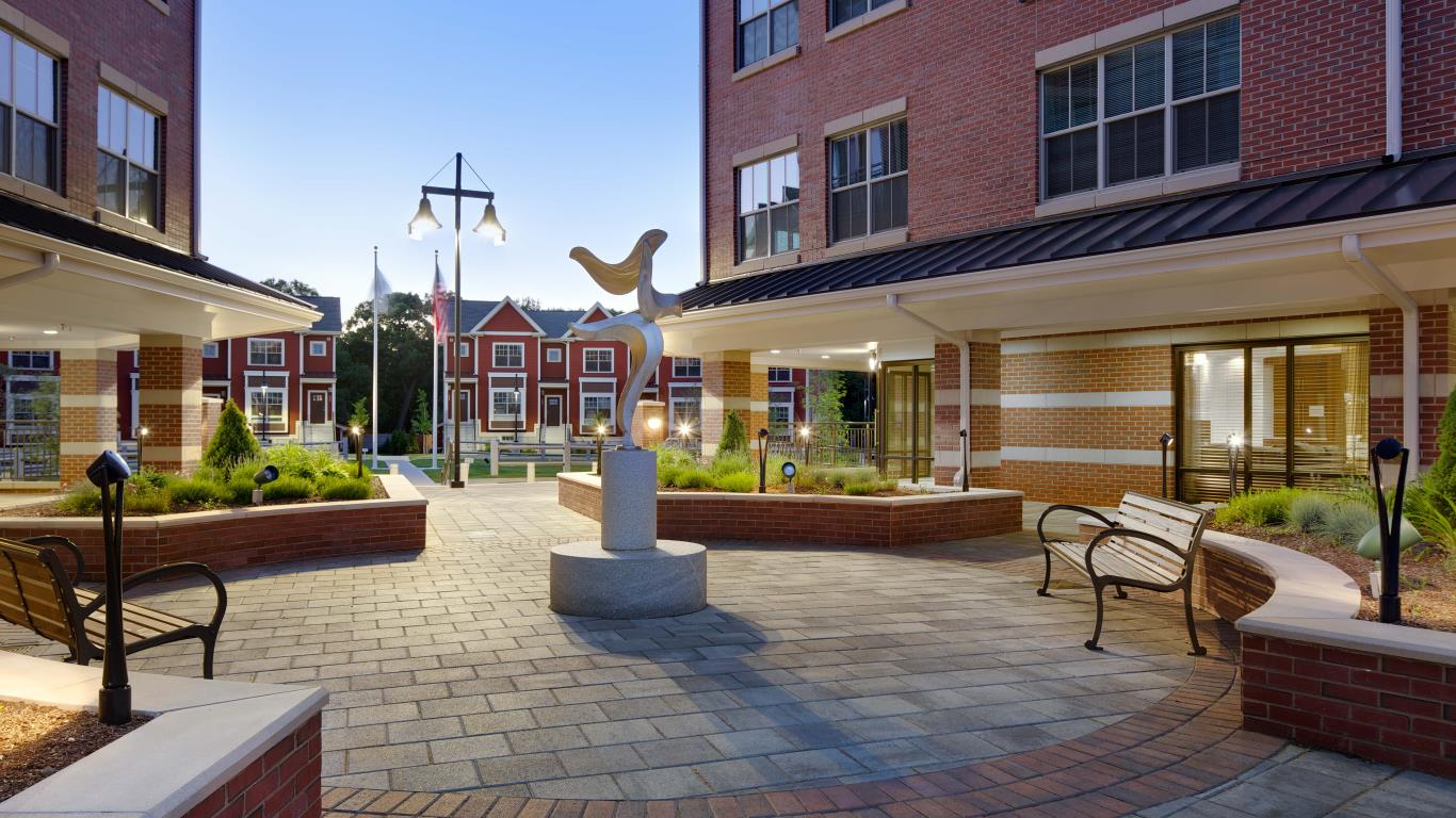arlington 360 courtyard with art sculpture, bench seating and view of apartment buildings in the distance - jefferson apartment group