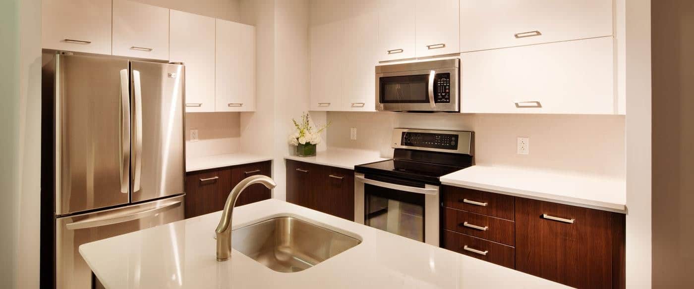 asher kitchen with two toned cabinetry, stainless steel appliances and quartz countertops - jefferson apartment group
