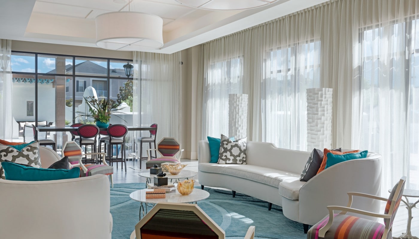 azul resident lounge with social seating, tables, chairs, large windows and modern lighting - jefferson apartment group