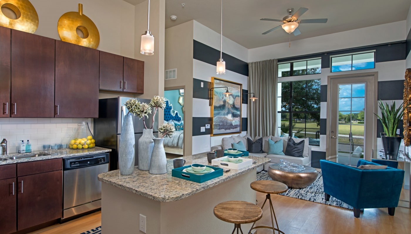 azul living area with couch, side chair, plank flooring, modern artwork and view of kitchen with granite countertops, espresso cabinetry, stainless steel appliances and modern lighting - jefferson apartment group