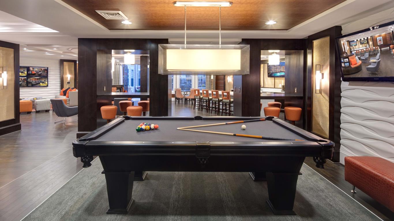 jefferson pointe game room with billiards, social seating, flat screen tv and view of bar area - jefferson apartment group