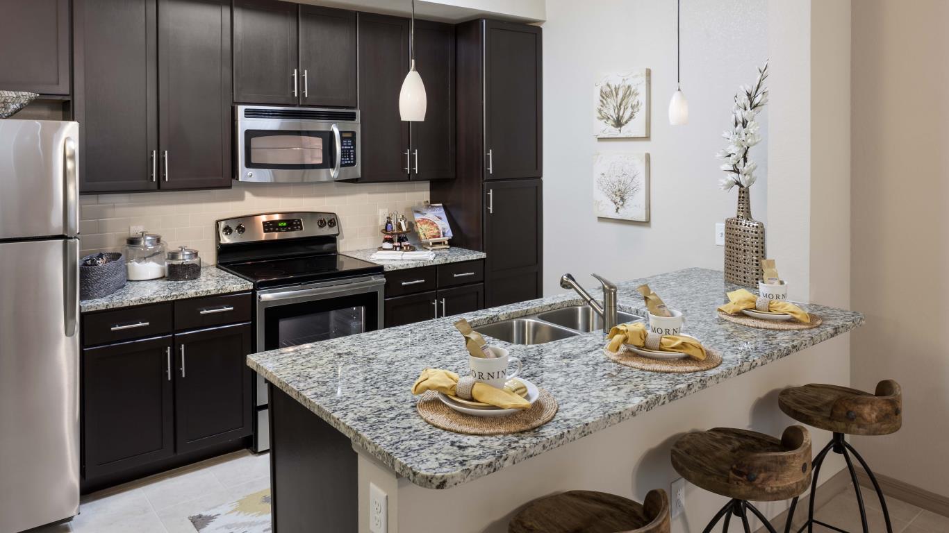 jefferson monterra kitchen with espresso cabinetry, granite countertops, stainless steel appliances and tiled flooring - jefferson apartment group