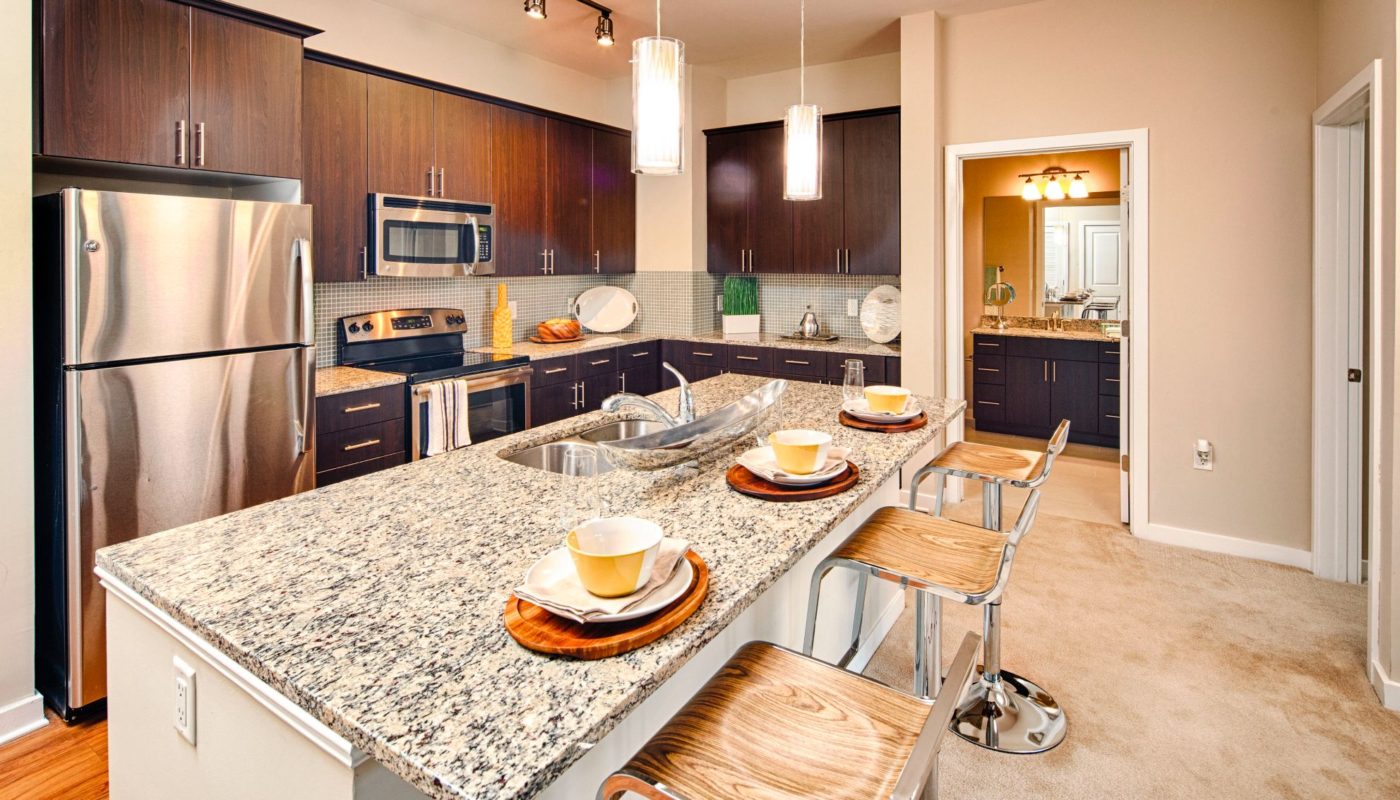 Kitchen with stainless steel appliances, modern cabinetry, and granite island at Jefferson square luxury Baltimore apartments
