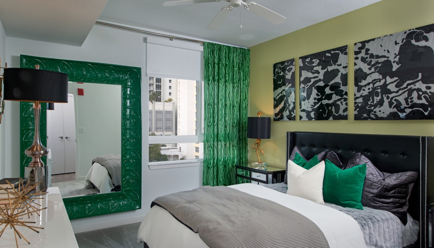 bedroom with bed, night stands, dresser, large mirror and modern artwork - jefferson apartment group
