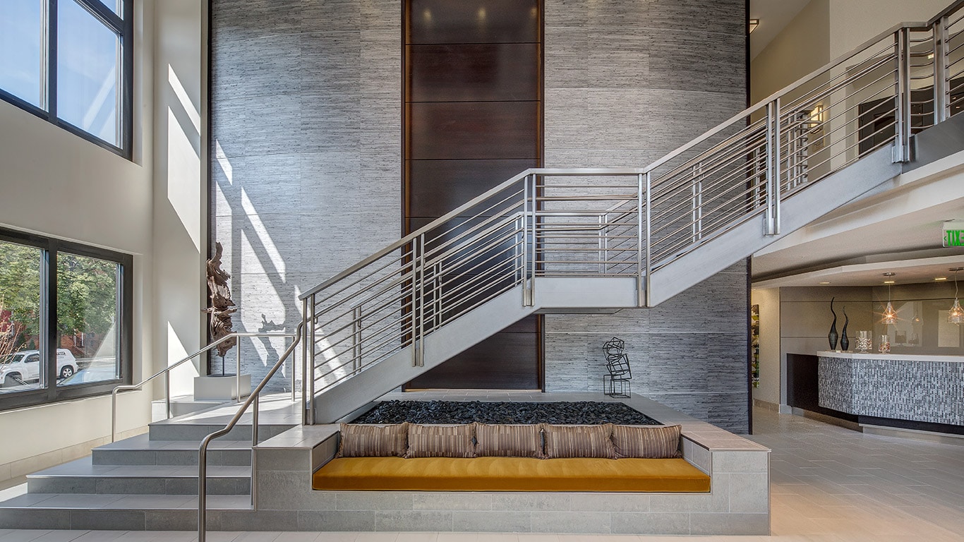 jefferson square lobby with grand staircase, bench seating and concierge desk - jefferson apartment group