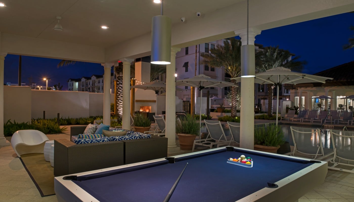 light house point outdoor game area with billiards table, social seating, and view of resort style pool and chaise lounge chairs - jefferson apartment group