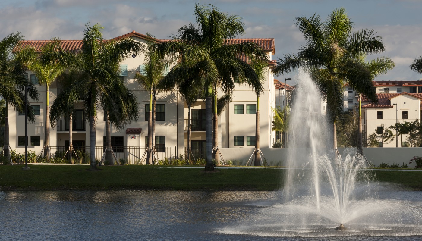 jefferson palm beach exterior showing a three story building with palm trees, a late and fountain - jefferson apartment group