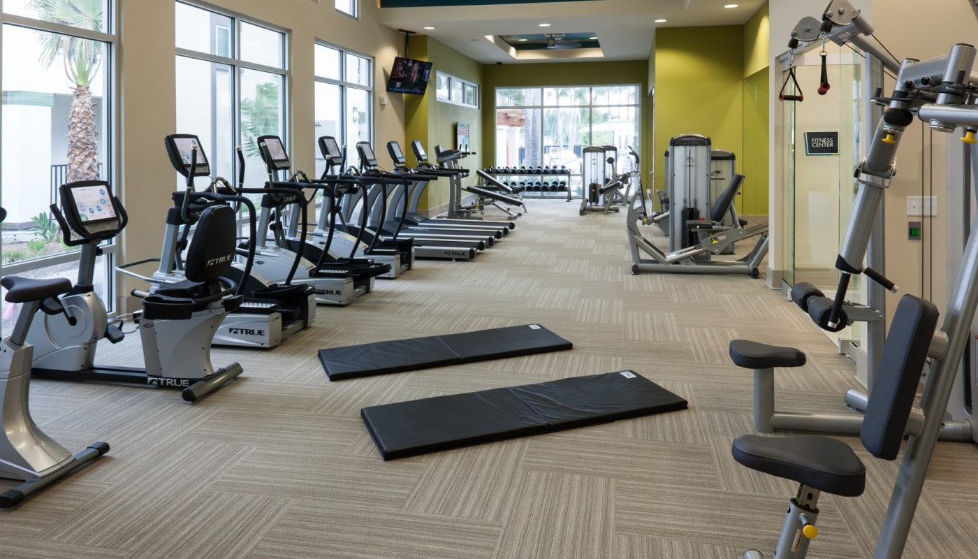 westshore fitness center with cardio equipment, strength training machines, flat screen tvs, large mirrors and large windows - jefferson apartment group