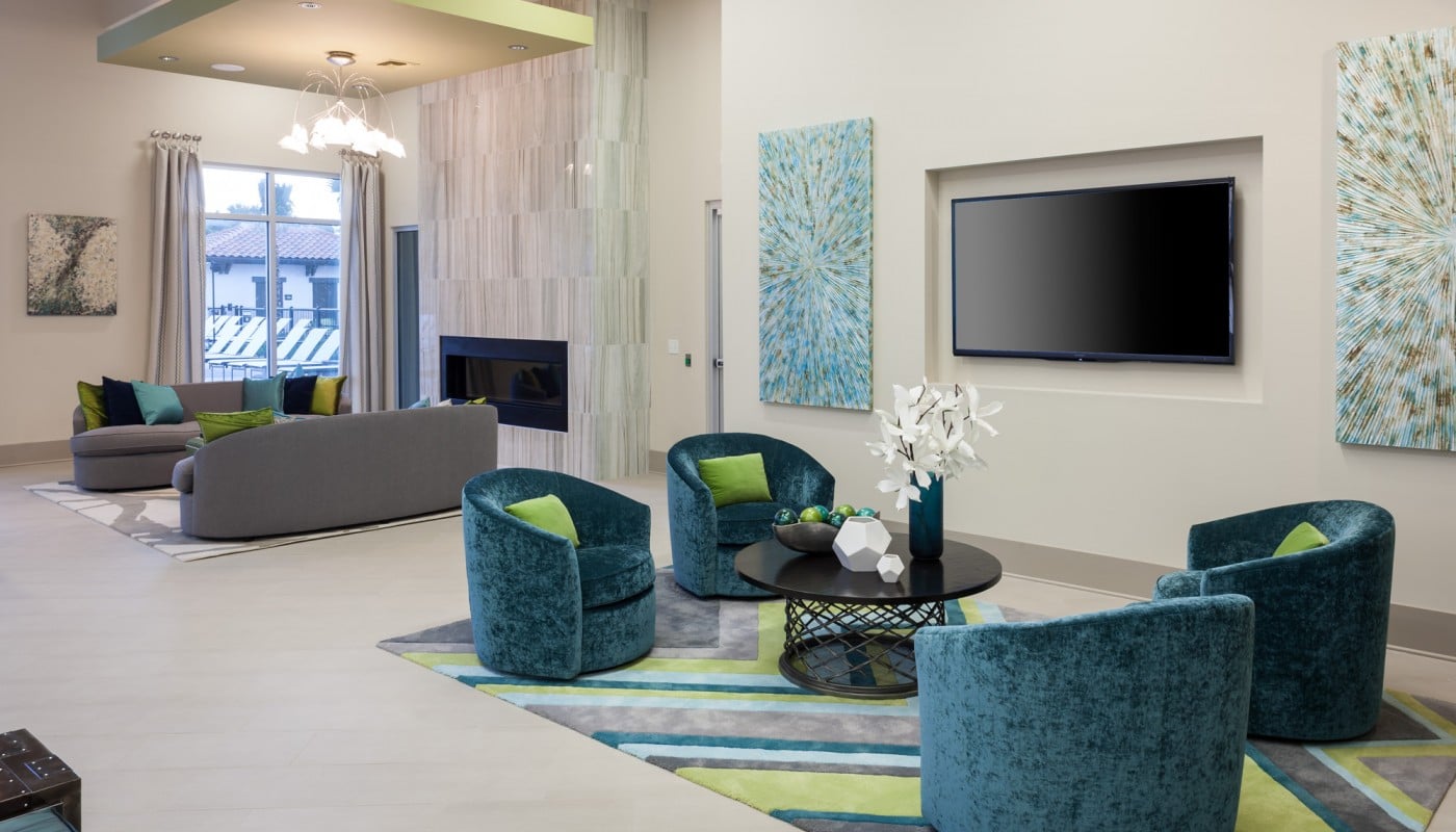 westshore resident lounge with fireplace, flatscreen tv, social seating and modern artwork - jefferson apartment group