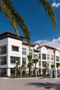 westshore exterior showing three story building with balconies, palm trees, and parking area - jefferson apartment group