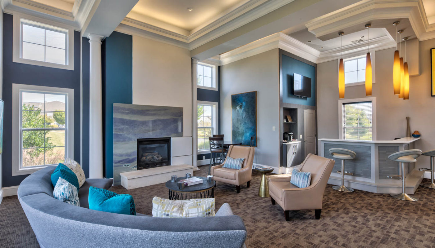 somerset park resident lounge with social seating, fireplace, bar seating, flat screen tv, large windows and modern lighting - jefferson apartment group