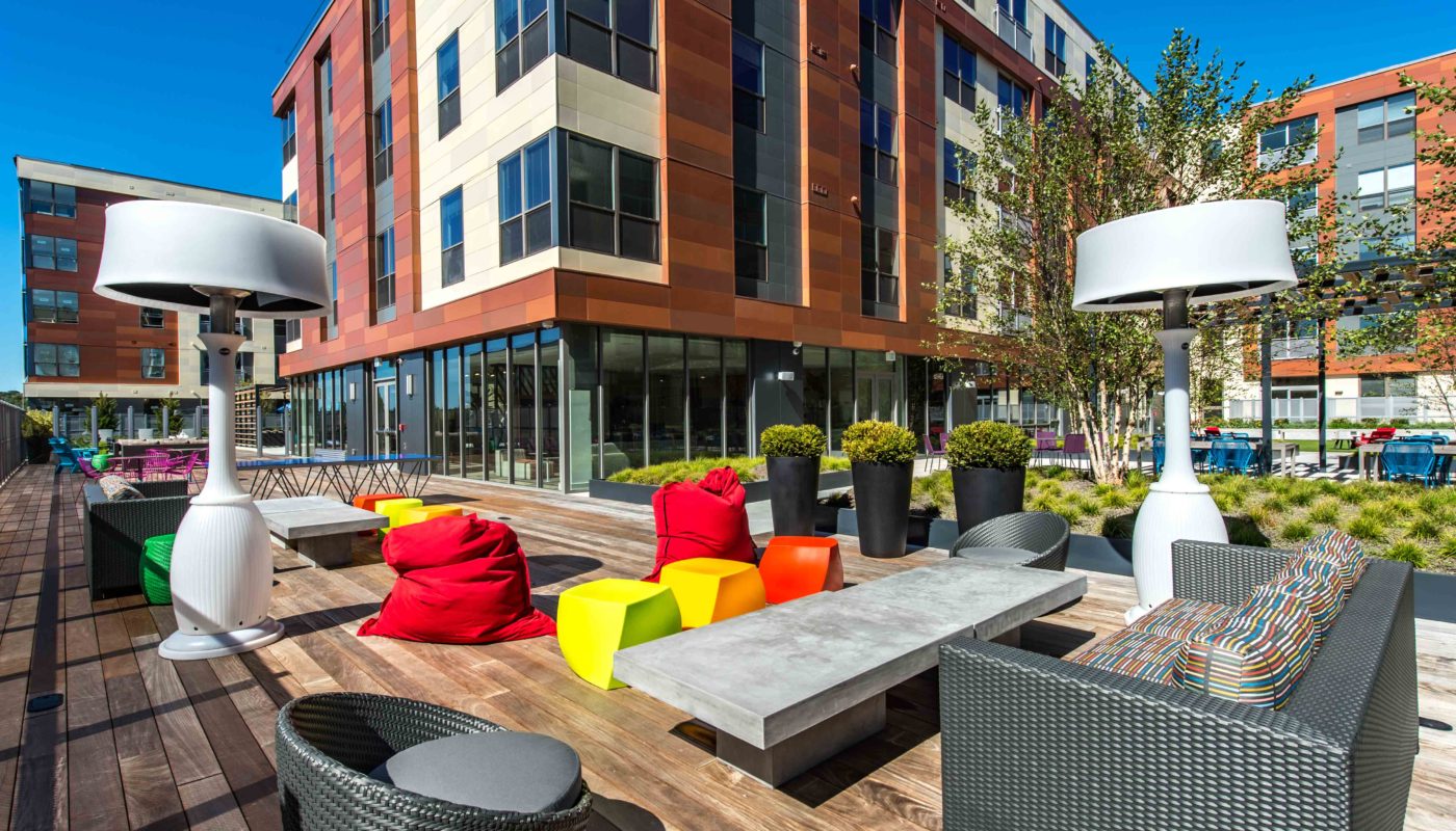 j malden outdoor courtyard with bean bag chairs, social seating, lush greenery and view of apartment building in the background - jefferson apartment group
