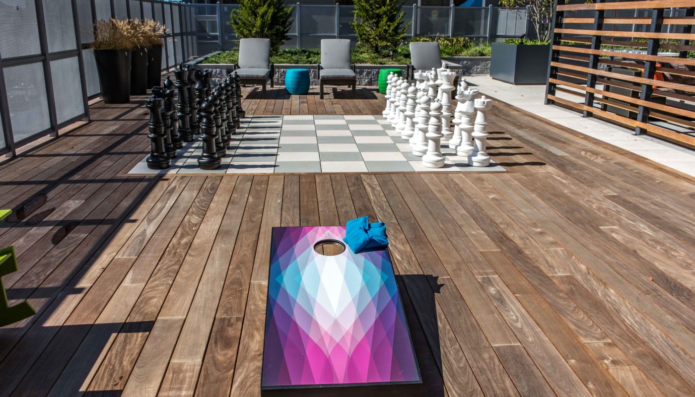 j malden center outdoor gaming area with corn hole boards and giant chess board - jefferson apartment group