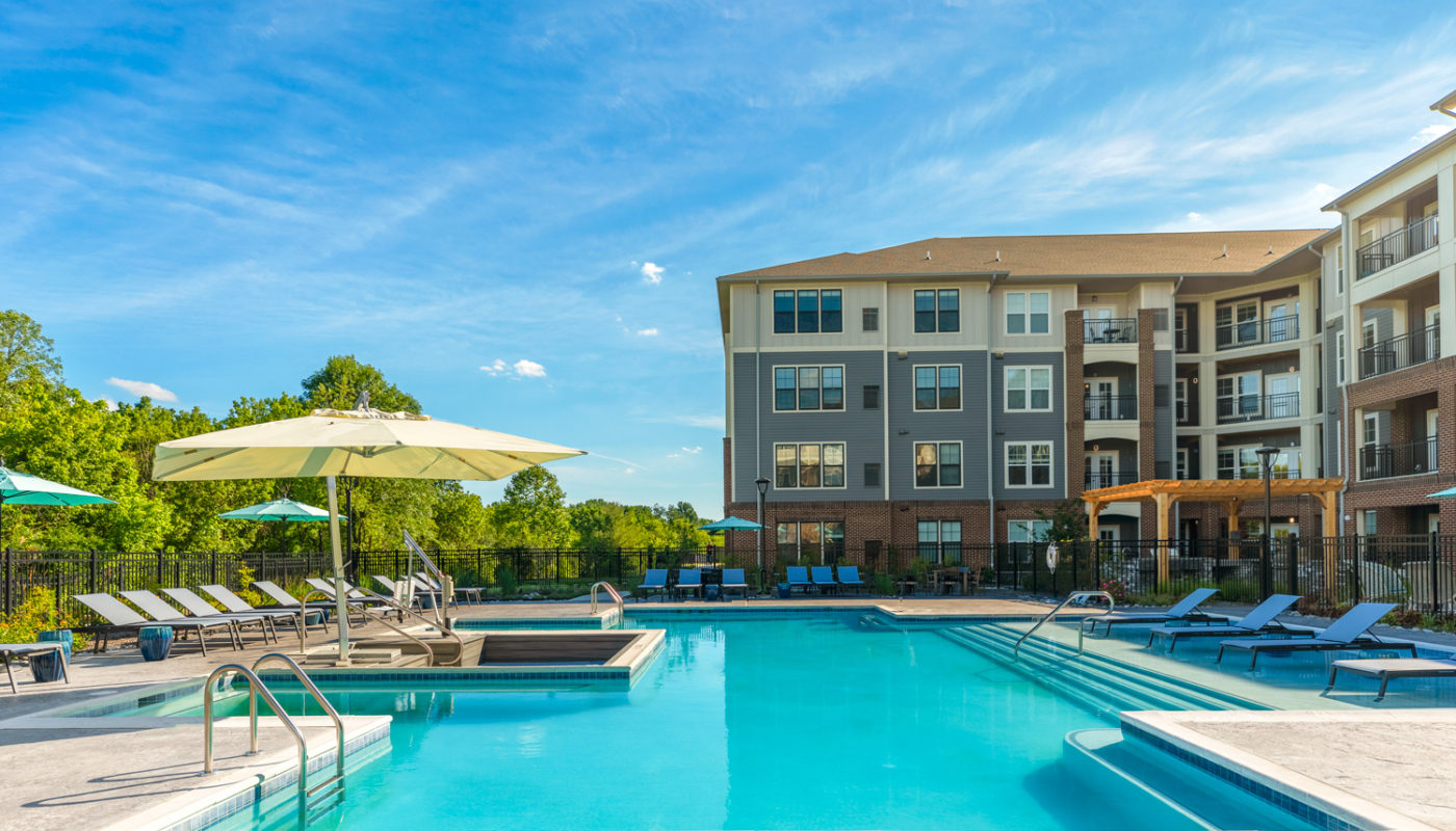 pool with lounge chairs, and umbrellas at j creekside luxury apartments in exton pa