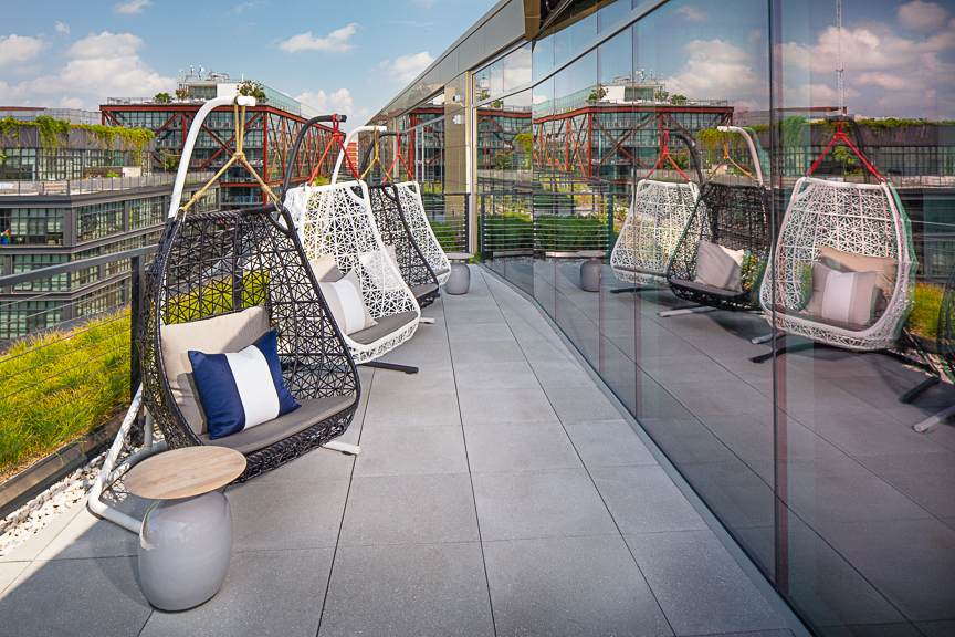 rooftop lounge swing chairs with view of city in the background