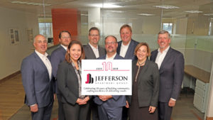 jefferson apartment group partners and leadship team with 20 year anniversary logo