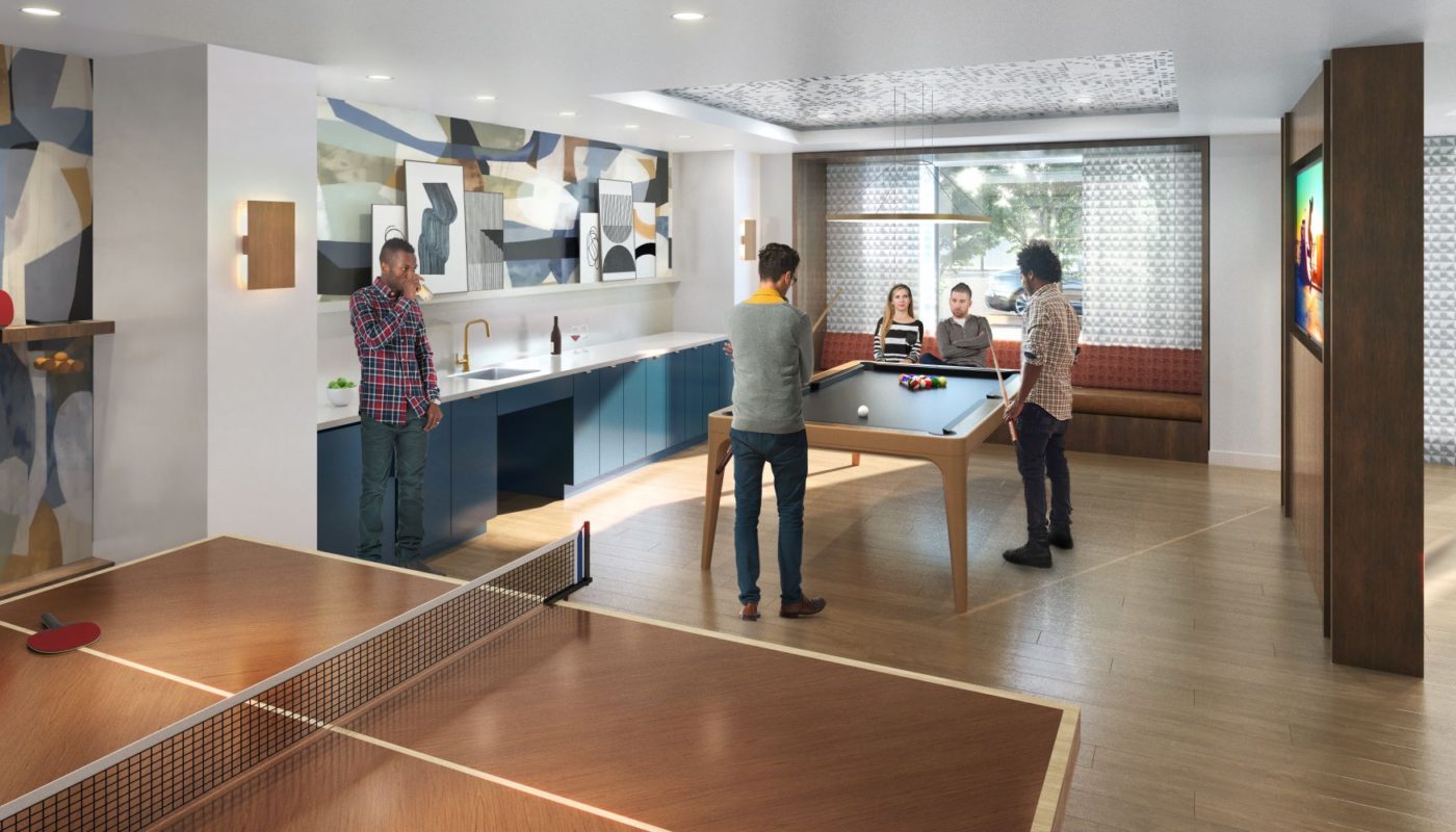 friends shooting pool in game lounge with ping pong table, kitchen, flat screen tv, billiards table and social seating