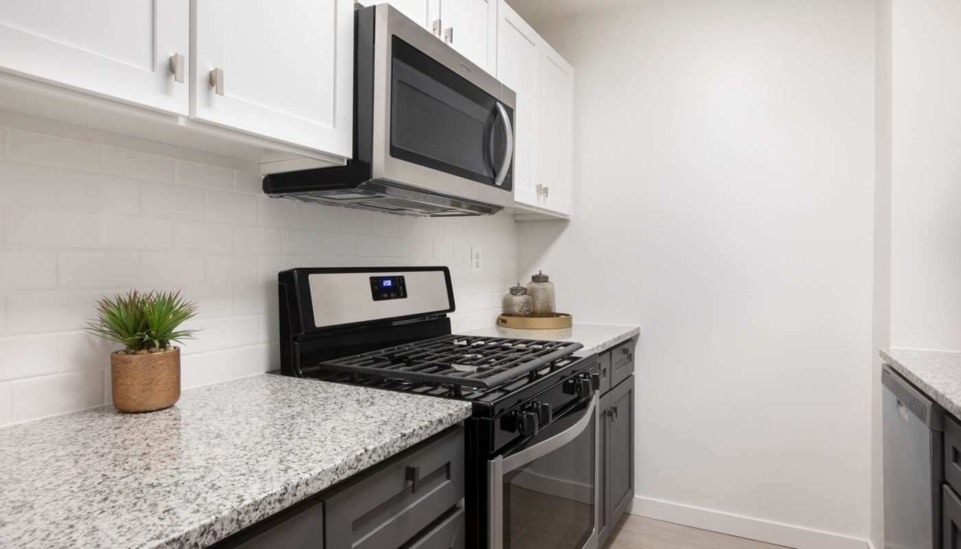 kitchen with granite counters and stainless steel appliances at j vue boston high rise apartments