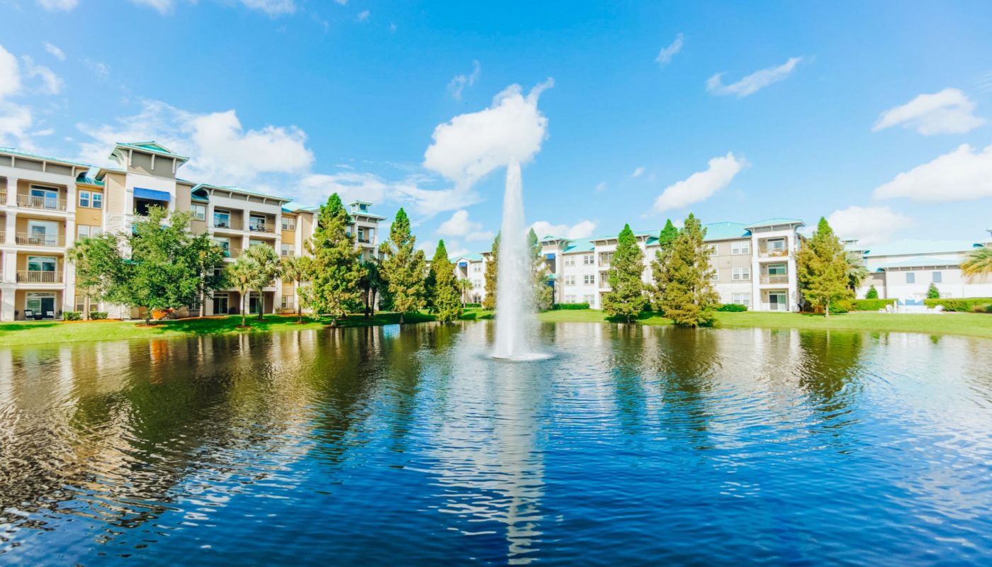 fountain in pond in front of sea isle orlando luxury apartments