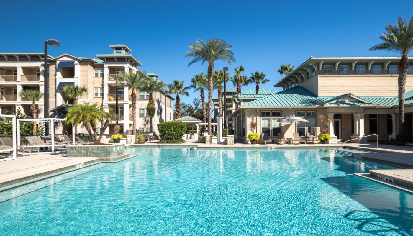 pool next to trees and building Sea Isle Orlando FL apartments)