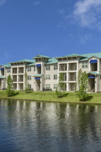 exterior view of pond and 3 story apartment building sea isle luxury apartments orlando