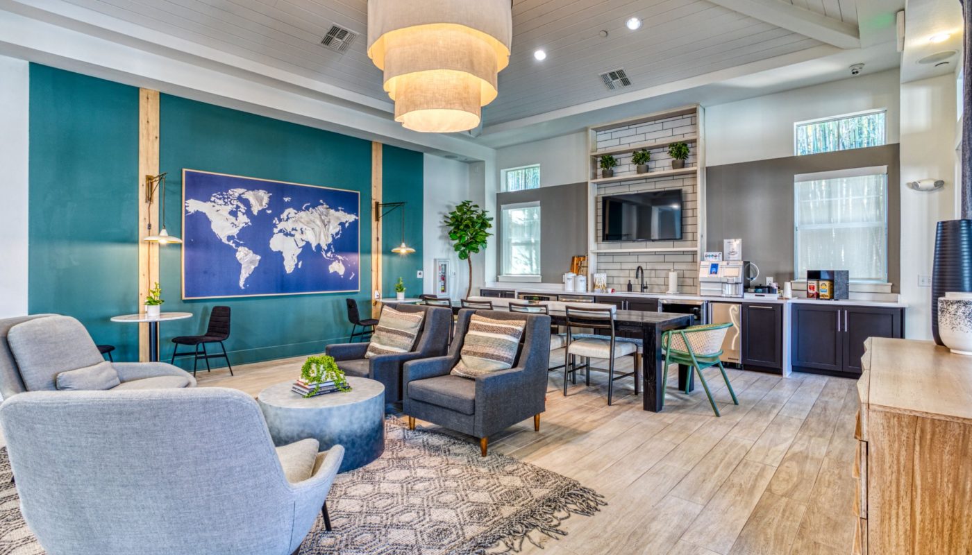 club room with social seating, flat screen tv, wall art and demonstration kitchen at sea isle orlando luxury apartments