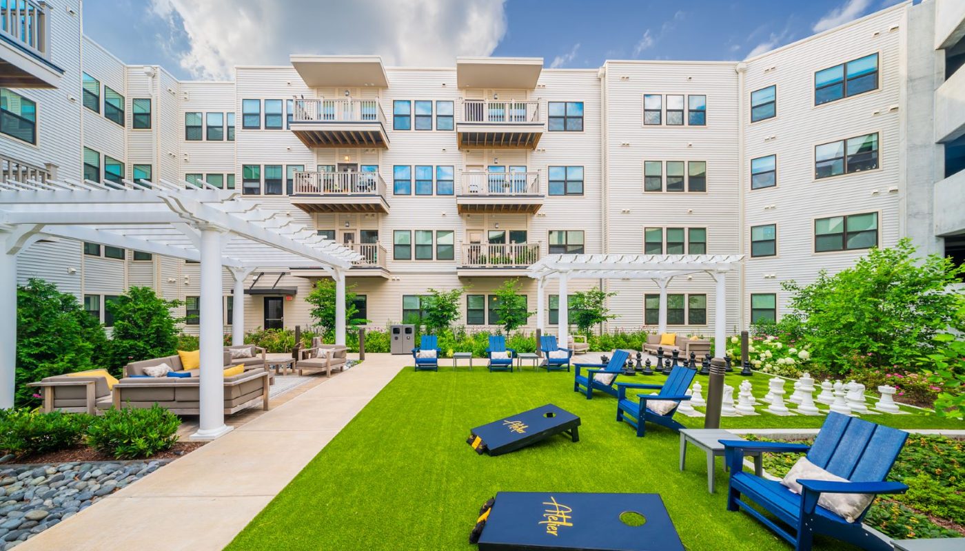 courtyard with seating and cornhole - atelier apartments glenmont metro