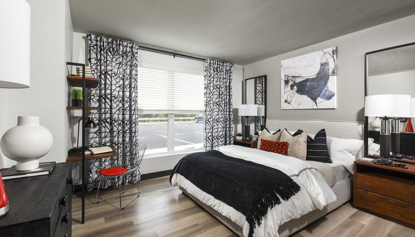 bedroom bed with sleek plank flooring J Woburn Heights apartments Woburn, MA