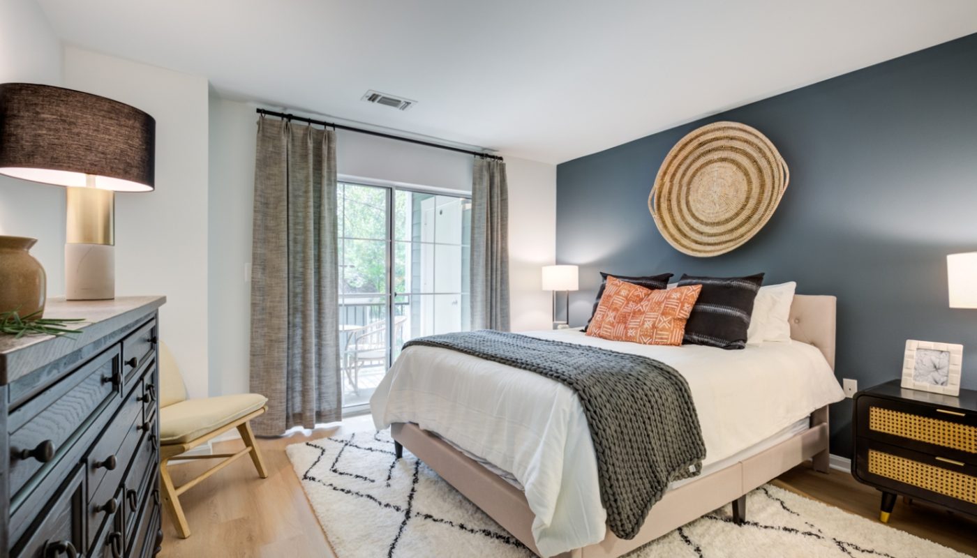 bedroom bed next to dresser and sleek plank flooring J Harbor Park Reston VA luxury apartments