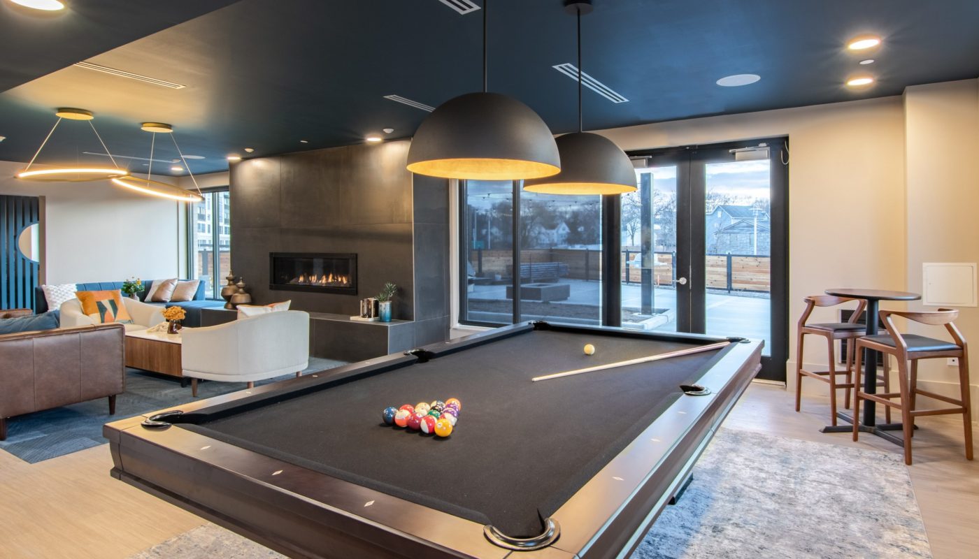 clubhouse pool table chairs and fireplace The Beam New London CT luxury apartments