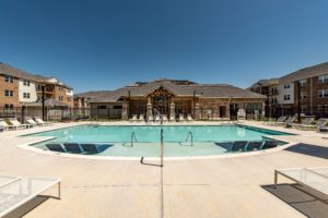 pool with chaises and clubhouse - brandywine green apartments