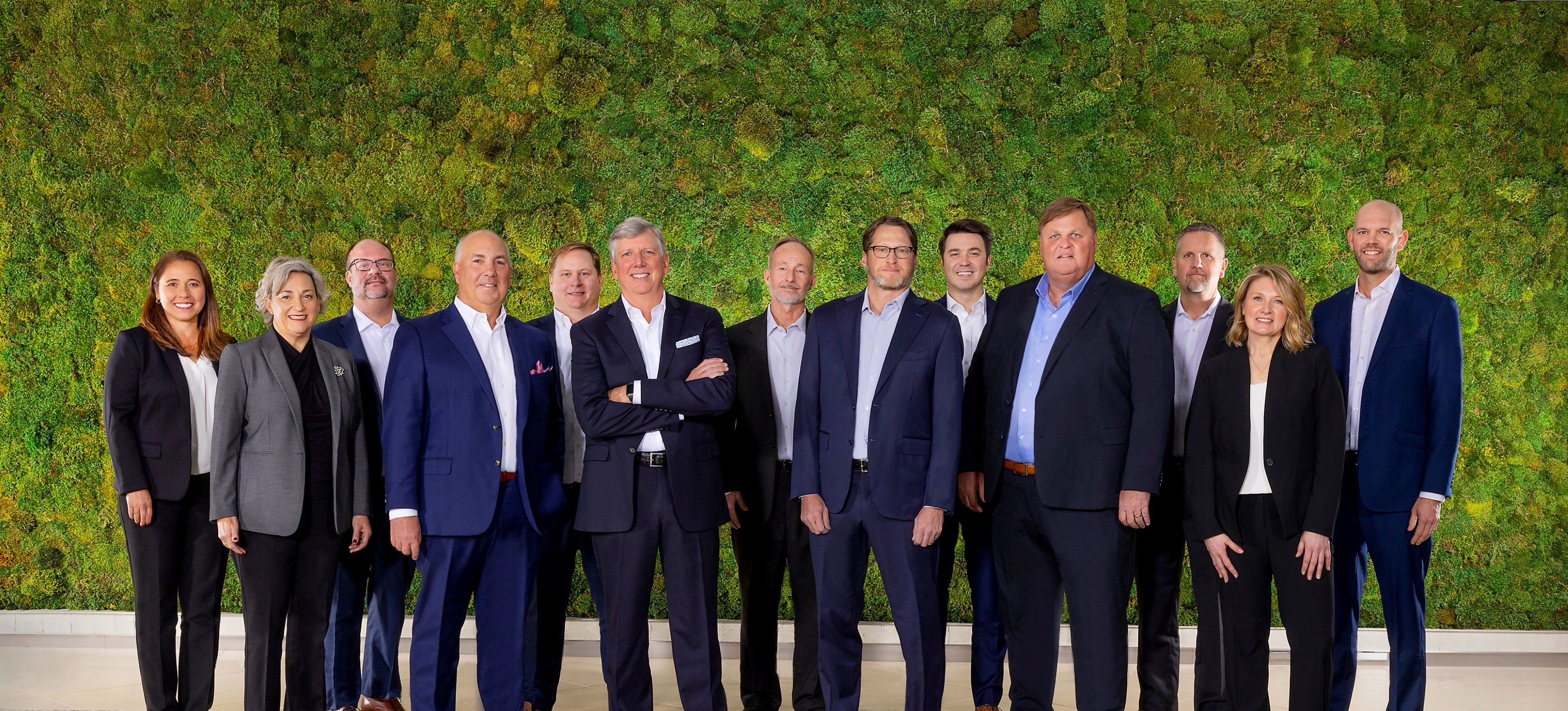 photo of JAG executives in front of a green wall