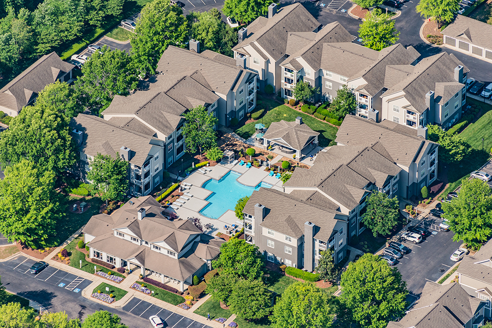 Aerial view with pool and garden style apartements at Jefferson Apartment Group