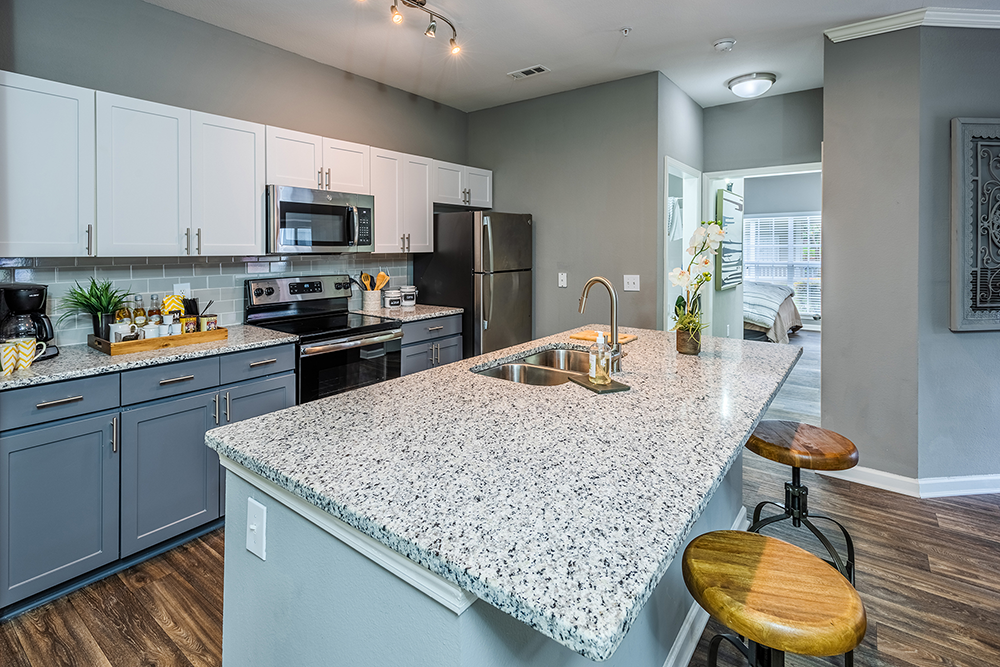 Remodeled Kitchen with grey and white cabinets and granite at Jefferson Apartment Group