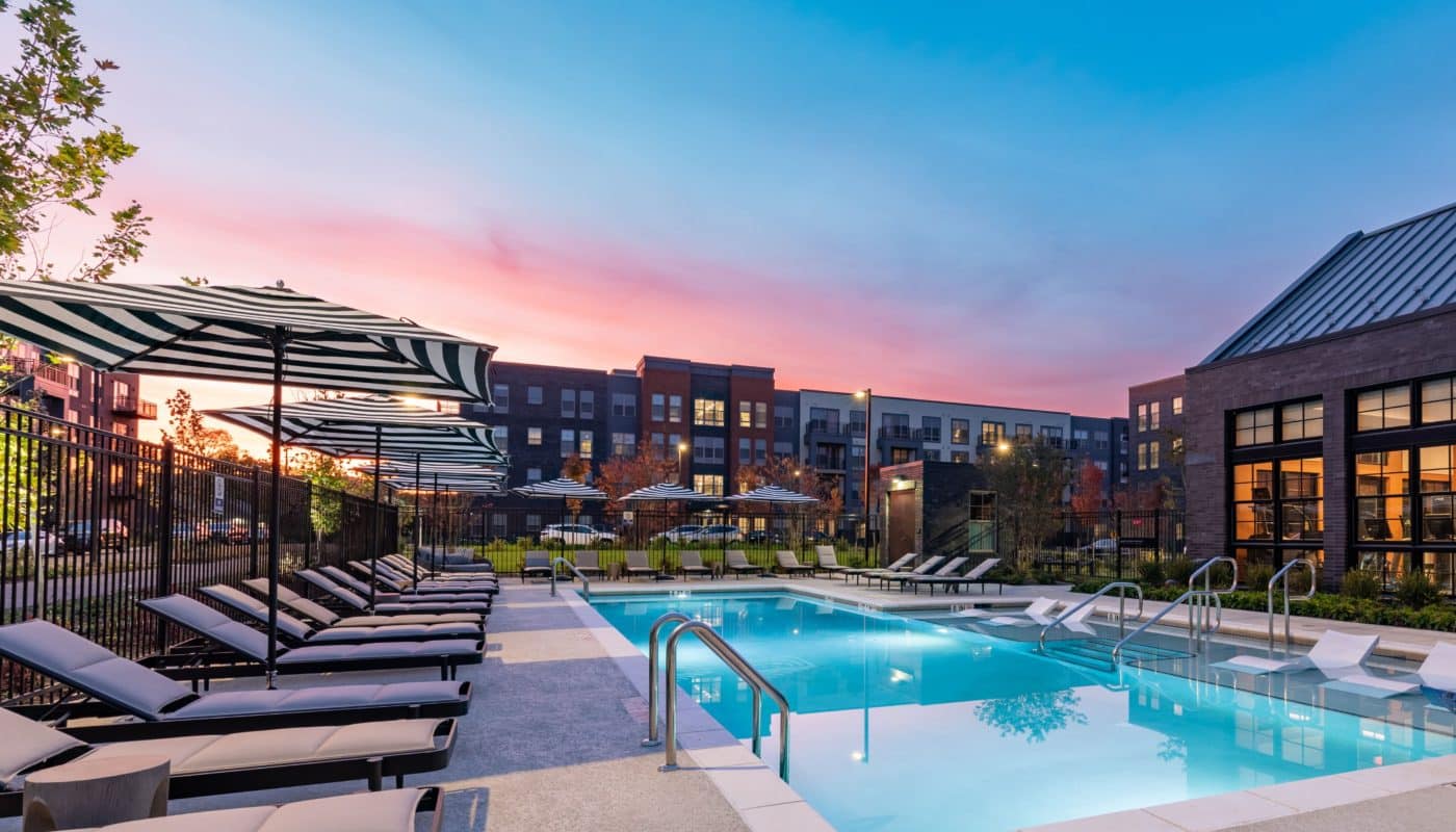 pool with sun shelf, day beds and lounge chairs dusk EDE luxury apartments Frederick MD